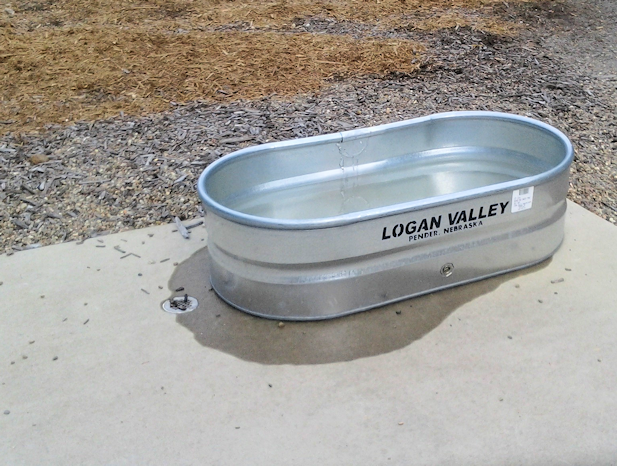 The big dog side of HSV DeSoto Dog Park has a galvanized tub for dogs to jump into and cool off.